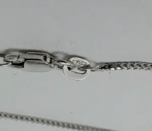 Silver chain clasp with hallmark detail.
