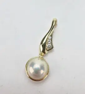 Gold pendant with pearl and diamonds.