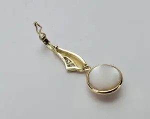 Gold earring with pearl and diamond accents.