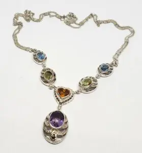 Silver necklace with colorful gemstone pendants.