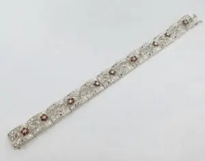 Silver bracelet with red gemstone accents.