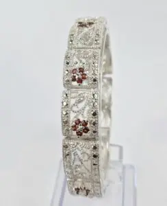Silver bracelet with intricate floral designs.