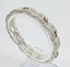 Intricate silver bracelet with red accents.