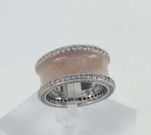 Silver band with pink enamel and diamonds.