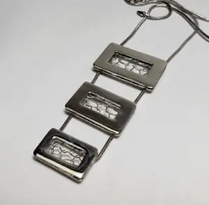 Geometric silver necklace with rectangular pendants.
