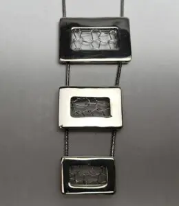 Geometric silver necklace with rectangular pendants.