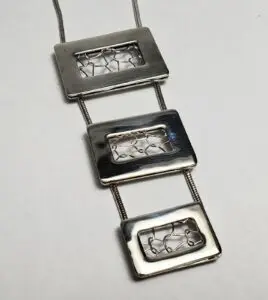 Silver rectangular pendant necklace with wire design.