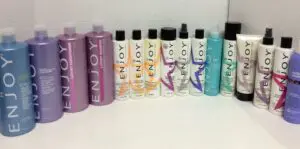 Various Enjoy hair care product bottles arranged.