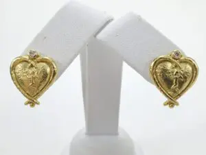 Gold heart-shaped earrings with angel design.