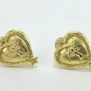 Gold heart-shaped earrings with cupid design.