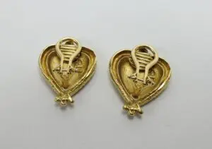 Gold heart-shaped earrings on white background.