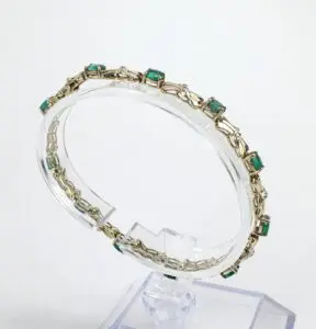 Gold bracelet with green gemstone accents.