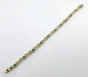 Gold bracelet with green gemstone accents.