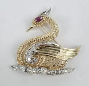 Gold and silver bird brooch with gemstones.