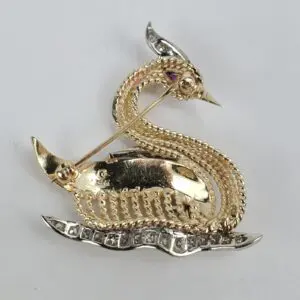 Gold dragon-shaped brooch with gemstones.