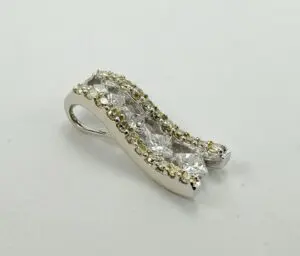 Silver pendant with diamonds on white background.