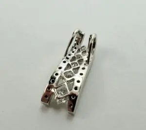 Silver metal jewelry clasp on white background.