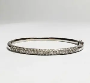 Silver bracelet with embedded diamonds on display.