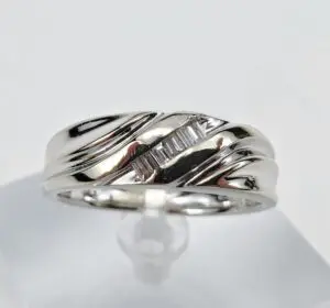 Silver ring with baguette diamonds on display.