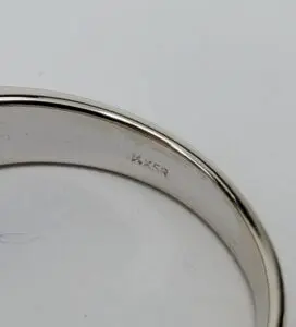 Silver ring with engraved markings on inside.