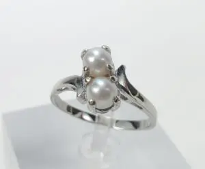 Silver ring with two pearl settings.