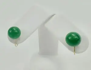 Green stud earrings on display stand.