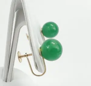 Green jade ball earrings on display stand.