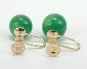 Gold and green gemstone cufflinks on display.