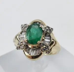 Gold ring with emerald and diamond accents.