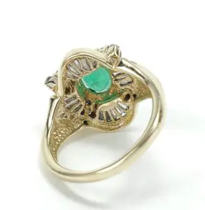 Gold ring with emerald and diamond accents.
