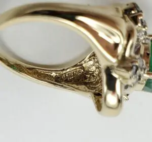 Gold ring with intricate detailing, side view.