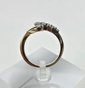Gold ring with diamonds on display stand.