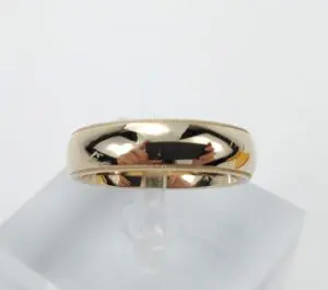 Gold ring with reflective surface on stand.
