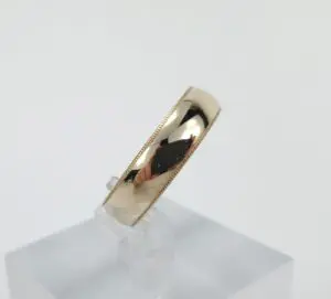 Gold ring on a clear stand.