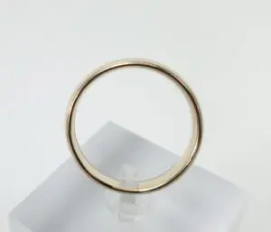 Gold ring on a white display stand.
