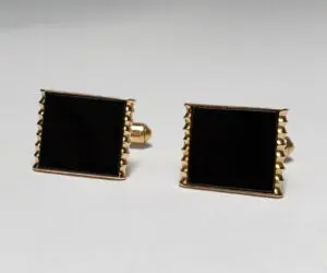 Gold and black square cufflinks on display.