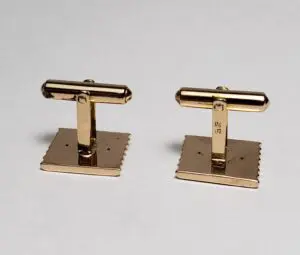 Gold cufflinks on a white background.