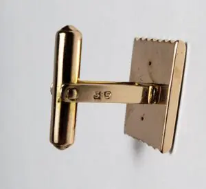 Gold cufflink with engraved numbers 3-5.