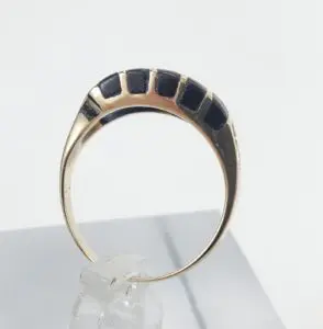 Gold ring with black rectangular inlays.