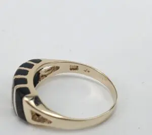 Gold ring with black inlay design.