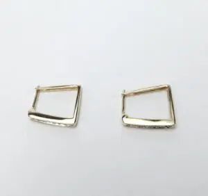 Gold geometric hoop earrings on white background.