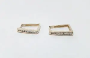 Gold square earrings with small diamonds.