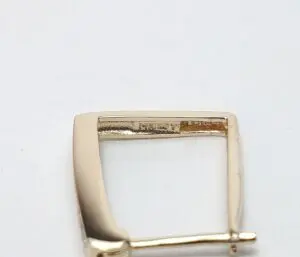 Gold buckle with engraved text detail.
