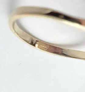 Gold ring with engraved hallmark.