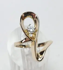 Gold ring with a diamond on display.