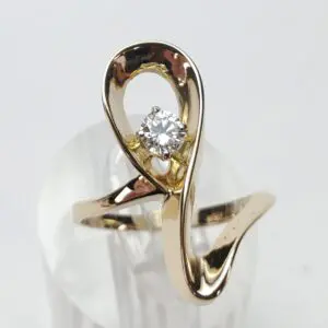 Gold ring with a diamond on display.