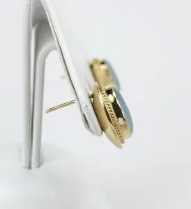 Gold earrings with blue stones displayed.