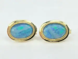 Gold earrings with oval blue opals.