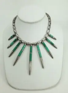 Silver and green beaded necklace on display.