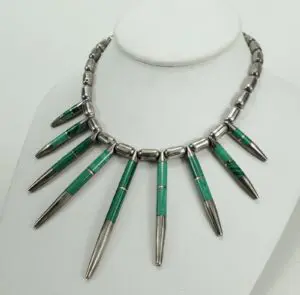 Green and silver necklace on display bust.